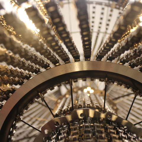  Een close-up van een kroonluchter met kettingen, geïnspireerd door een fietswiel lamp.