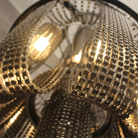 Gedetailleerde close-up van een metalen ketting met een gloeilamp, die het innovatieve ontwerp van de fietskettinglamp benadrukt.